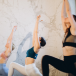 Gruppo di ragazze che praticano in gruppo in uno studio di Yoga