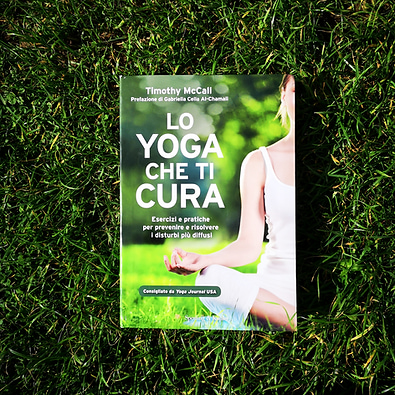 Libri sullo Yoga: "lo Yoga che ti cura" di Timothy McCall sul prato in un giorno di sole